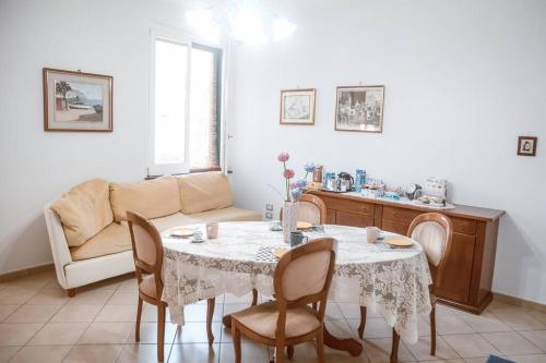 uma sala de estar com uma mesa e cadeiras e um sofá em Annabella's Country House historic apartment em SantʼAntonio Abate
