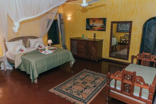 a bedroom with two beds and a mirror at Hotel Villa Malindi in Malindi