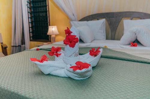 a hotel room with towels and flowers on a bed at Hotel Villa Malindi in Malindi