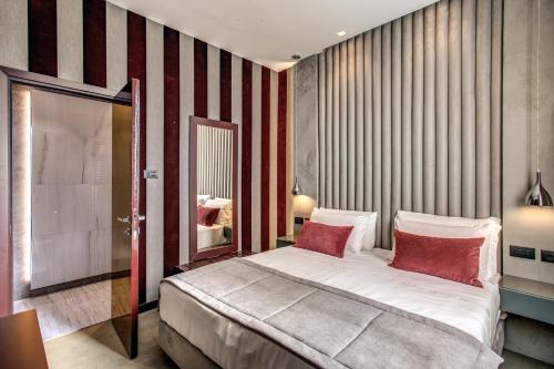 a bedroom with a large bed with red and white stripes at Doria Palace Boutique Hotel in Rome