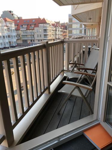 a balcony with a chair and a view of a city at Fleur II in Knokke-Heist