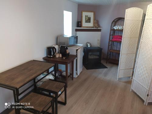 a room with wooden tables and chairs and a kitchen at Chambre tranquille et confortable pour étape in Ancy-le-Libre