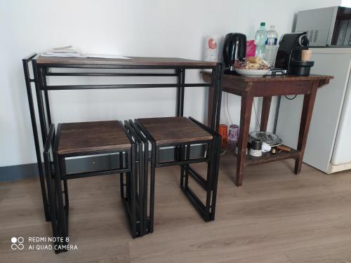 a table and two stools next to a table and a counter at Chambre tranquille et confortable pour étape in Ancy-le-Libre