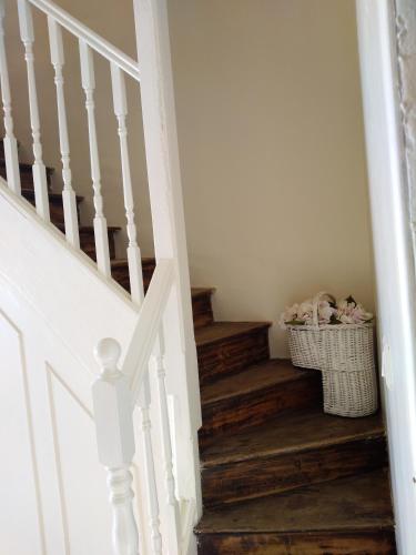 una escalera con una cesta de ropa en una habitación en Au Cœur de Ménestérol Chambre Émotion, en Montpon-Ménestérol