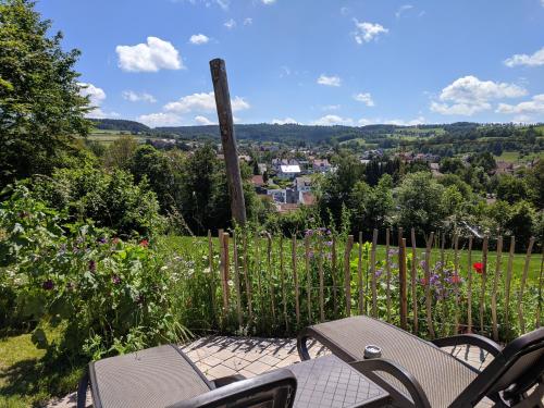 a patio with two chairs and a view of a city at Rhön Lodge in Poppenhausen