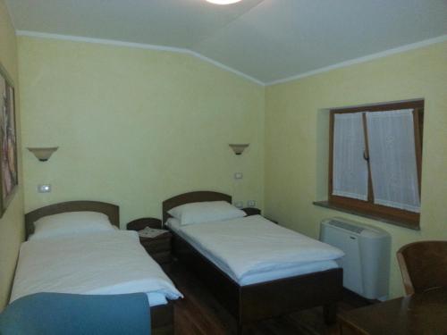 two beds in a small room with a window at Arkade turizem in Črniče