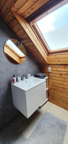 a bathroom with a white sink and a skylight at Close to centre, 3 rooms, 2 bathr & wc, free parking & wifi, spacious living area & kitchen in Bruges