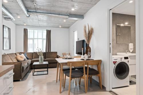 a kitchen and living room with a table and chairs at Aalesund City Apartment in Ålesund
