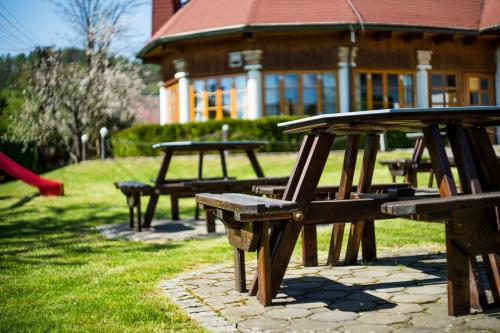 a group of picnic benches in front of a building at Penzion Terasa, bed & breakfast in Velké Losiny