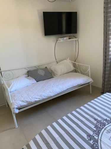 een bed in een kamer met een tv aan de muur bij Villa ,Maison indépendante, avec piscine privative in Puget-sur Argens