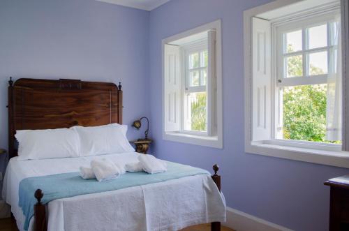 a bedroom with two towels on a bed with two windows at Porto.arte guest apartments in Porto