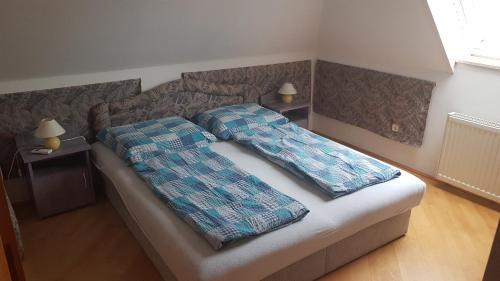 a bedroom with a bed with two pillows on it at Royal Apartman in Vonyarcvashegy