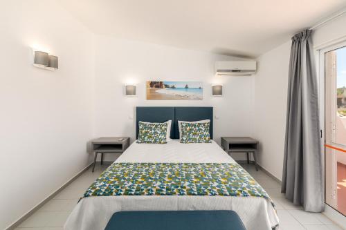 a bedroom with a bed and two tables at Moradias Villas Joinal in Albufeira