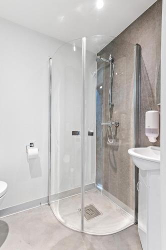 a shower with a glass door in a bathroom at Aalesund City Apartment in Ålesund