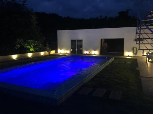 a swimming pool lit up at night with lights at Chiang Khan Riverside Pool Villa in Chiang Khan