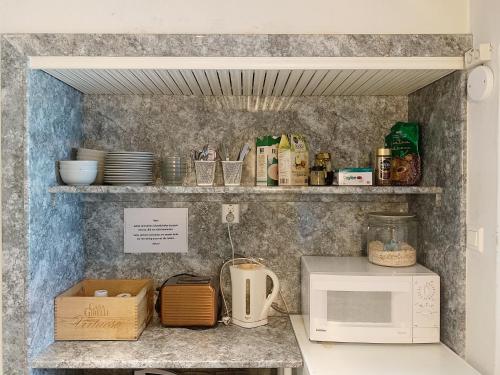 a kitchen with a counter top with a microwave at Hotel Harriet in Turku