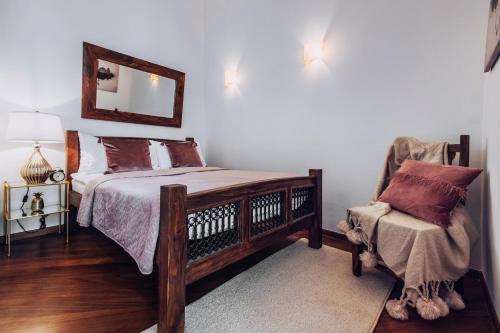 sypialnia z łóżkiem, krzesłem i lustrem w obiekcie Szpitalna 20 Apartment nr 8 w Krakowie