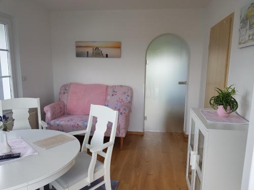 salon ze stołem i różową kanapą w obiekcie Ferienwohnung Pfeil w mieście Blankenheim