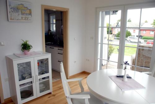 - une cuisine avec une table et une table et des chaises blanches dans l'établissement Ferienwohnung Pfeil, à Blankenheim