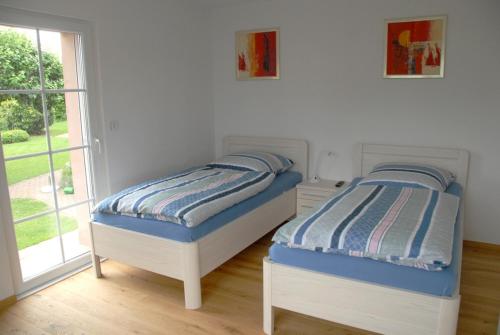 2 łóżka pojedyncze w pokoju z oknem w obiekcie Ferienwohnung Pfeil w mieście Blankenheim
