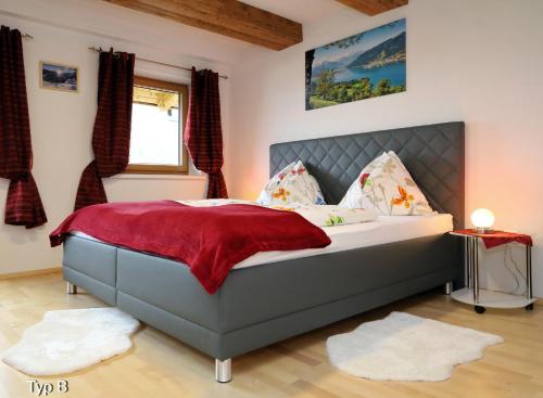a bedroom with a large bed with a red blanket at Chalet Der Bichlhof in Zell am See