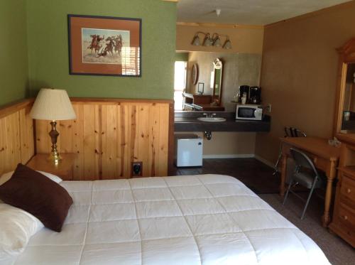 a bedroom with a large white bed and a desk at Whitney Portal Hotel And Hostel in Lone Pine