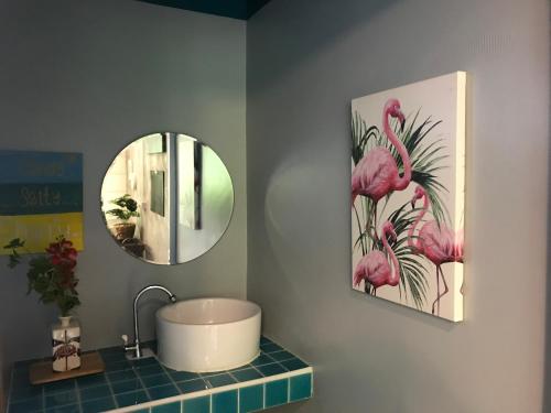 a bathroom with a sink and a mirror and pink flamingos at SeaEsta Beach in Ban Tai