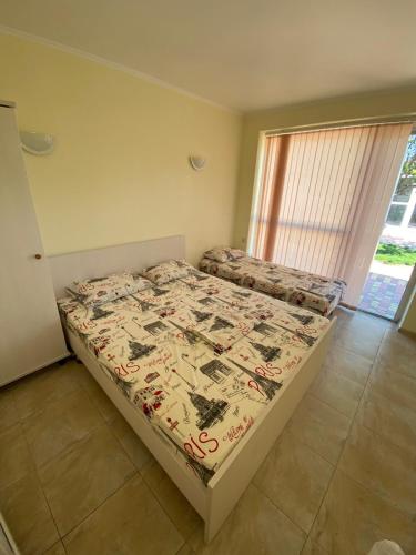 a bedroom with a bed with a comforter on it at Villa Lina in Karolino-Buhaz