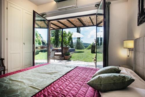 a bedroom with a large bed in front of a glass door at Sestuccina in Gaiole in Chianti