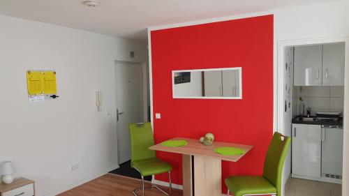 シュトゥットガルトにあるApartment Gablenbergの赤い壁のキッチン、テーブルと椅子