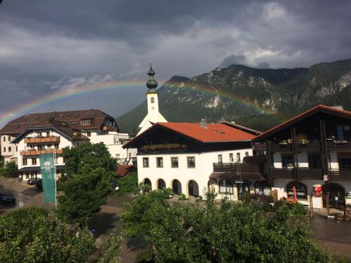 a rainbow in the sky over a town with a church at Ferienwohnung Traudl in Inzell