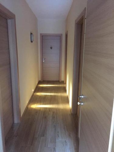 an empty hallway with a door and a wooden floor at Saint Patrick's INN in Limone Piemonte