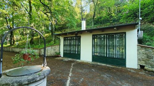 ein kleines Haus mit einer grünen Tür und einem Brunnen in der Unterkunft Villa Sargiano in Arezzo