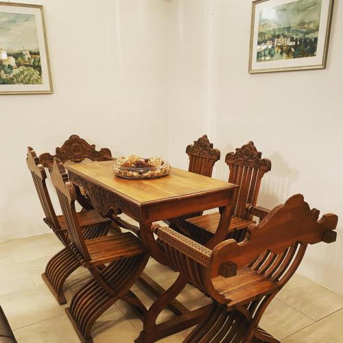 a wooden table with four chairs around it at Villa HerMes ArT in Dutovlje