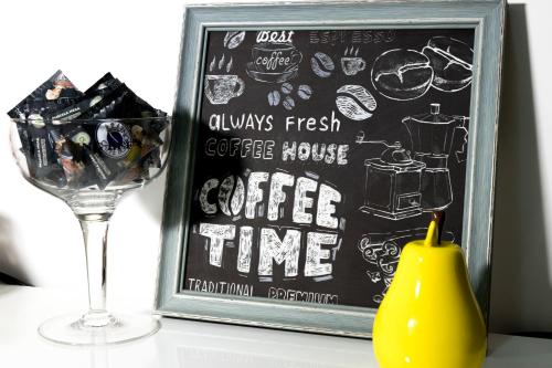 eine Tafel mit Kaffeehauskaffee und einem Glas in der Unterkunft Megaride Santa Lucia in Neapel