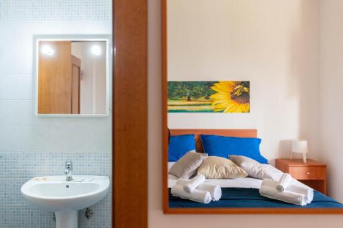 bagno con letto, lavandino e specchio di Residence Catona a Otranto