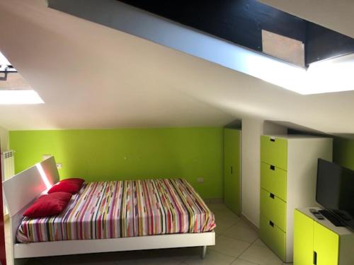 - une chambre dotée d'un lit avec un mur vert dans l'établissement Appartamento vacanze Fondi, à Fondi