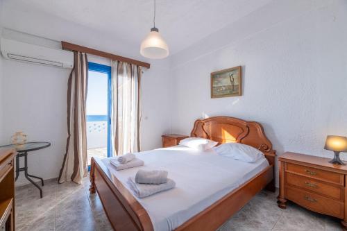- une chambre avec un lit doté de draps blancs et une fenêtre dans l'établissement Golden sunset beach house, à Skála Foúrkas