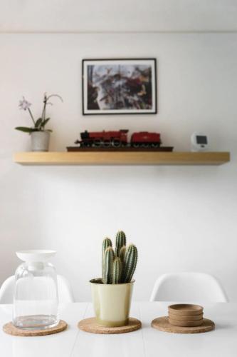 a table with a plant and a train on a shelf at The Film Studio Appartement 5 min to Harry Potter in Leavesden Green
