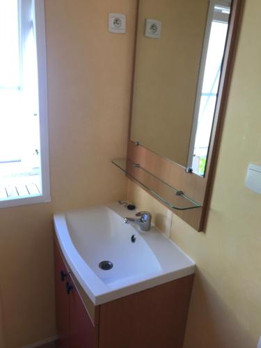 a bathroom with a sink and a mirror at Mobil Home à Meschers au camping l'Escale proche de Royan in Meschers-sur-Gironde