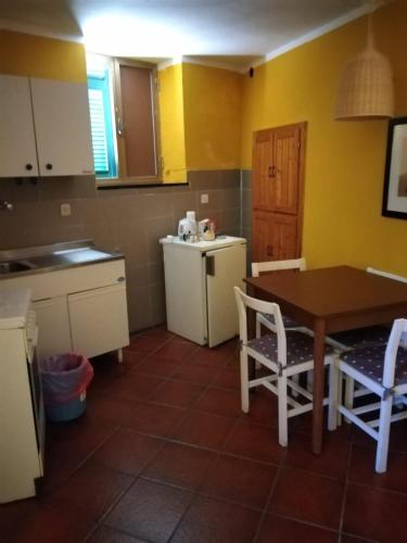 a kitchen with a table and chairs and a table and yellow walls at Appartamento Rosa in Montale