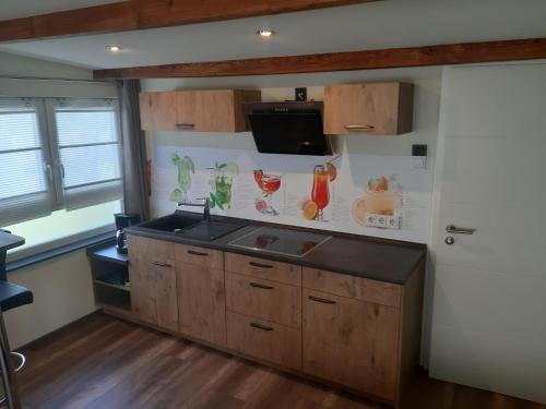 eine Küche mit einem Waschbecken und einem TV an der Wand in der Unterkunft Appartement Merl in Saarwellingen