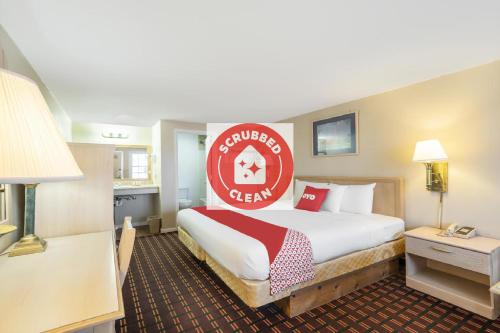 una habitación de hotel con una cama con un letrero rojo. en OYO Hotel Starlite Seneca Falls, en Seneca Falls