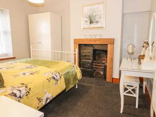 a bedroom with a bed and a fireplace at Mill Cottage in Belford