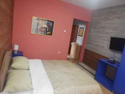 um quarto com uma cama e uma televisão de ecrã plano em B & B 903ta em Skopje