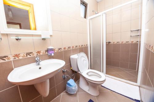 a bathroom with a toilet and a sink and a shower at Villa Gardenia in Dalyan