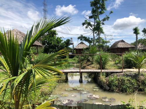 a bridge over a pond with lily pads at MEKONG DANIEL HOMESTAY CAN THO in Can Tho