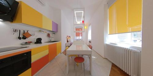 una cucina con armadi dai colori vivaci e tavolo di Dada a Trieste