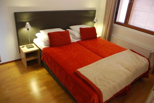 um quarto com uma cama grande e um cobertor vermelho em Ylläs Chalet 8208 em Ylläs