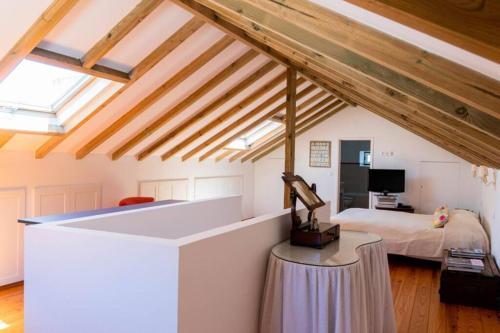 een slaapkamer met een bed in een kamer met houten plafonds bij Sintra • Banzão House with Swimming Pool in Nafarros